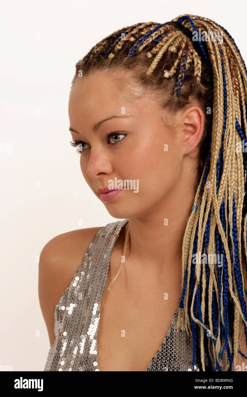 young woman with cat like eyes and braids in her hair in a silver party or clubbing dress Stock Photo