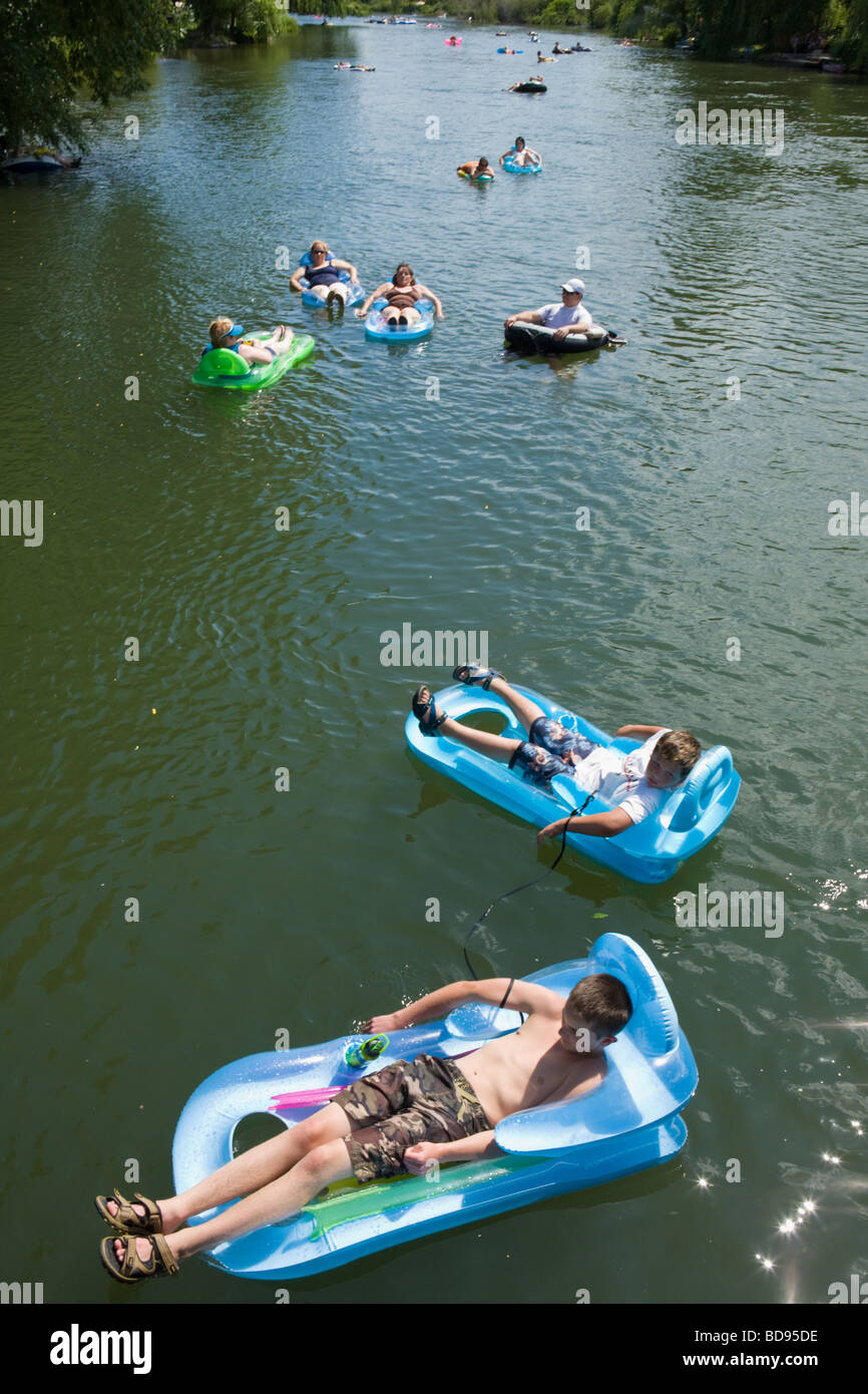 Many people leisurely floating on rafts down the Deschutes River on
