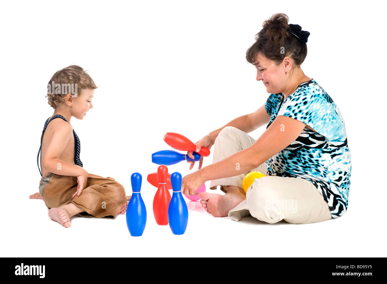 people on white mother with boy play skittles Stock Photo