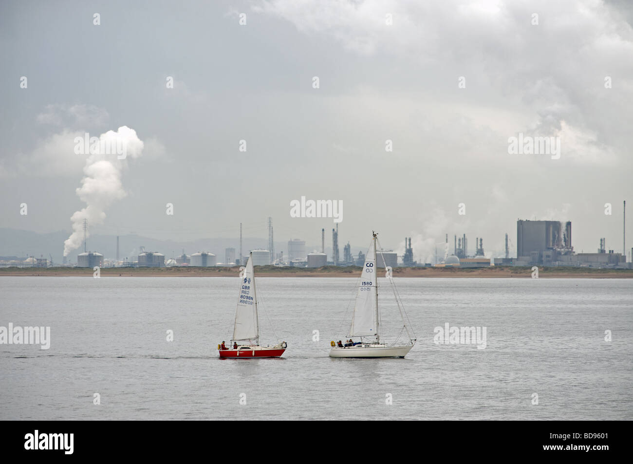 Yachts sailing past a nuclear power station and oil refinery Hartlepool, Cleveland, UK Stock