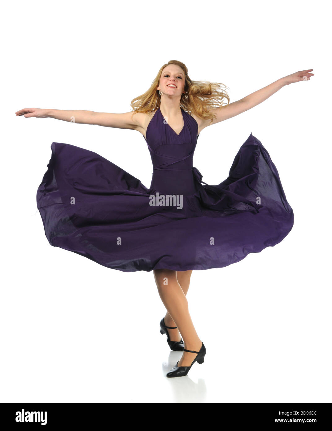 Young woman dancing with dress blowing isolated over a white background