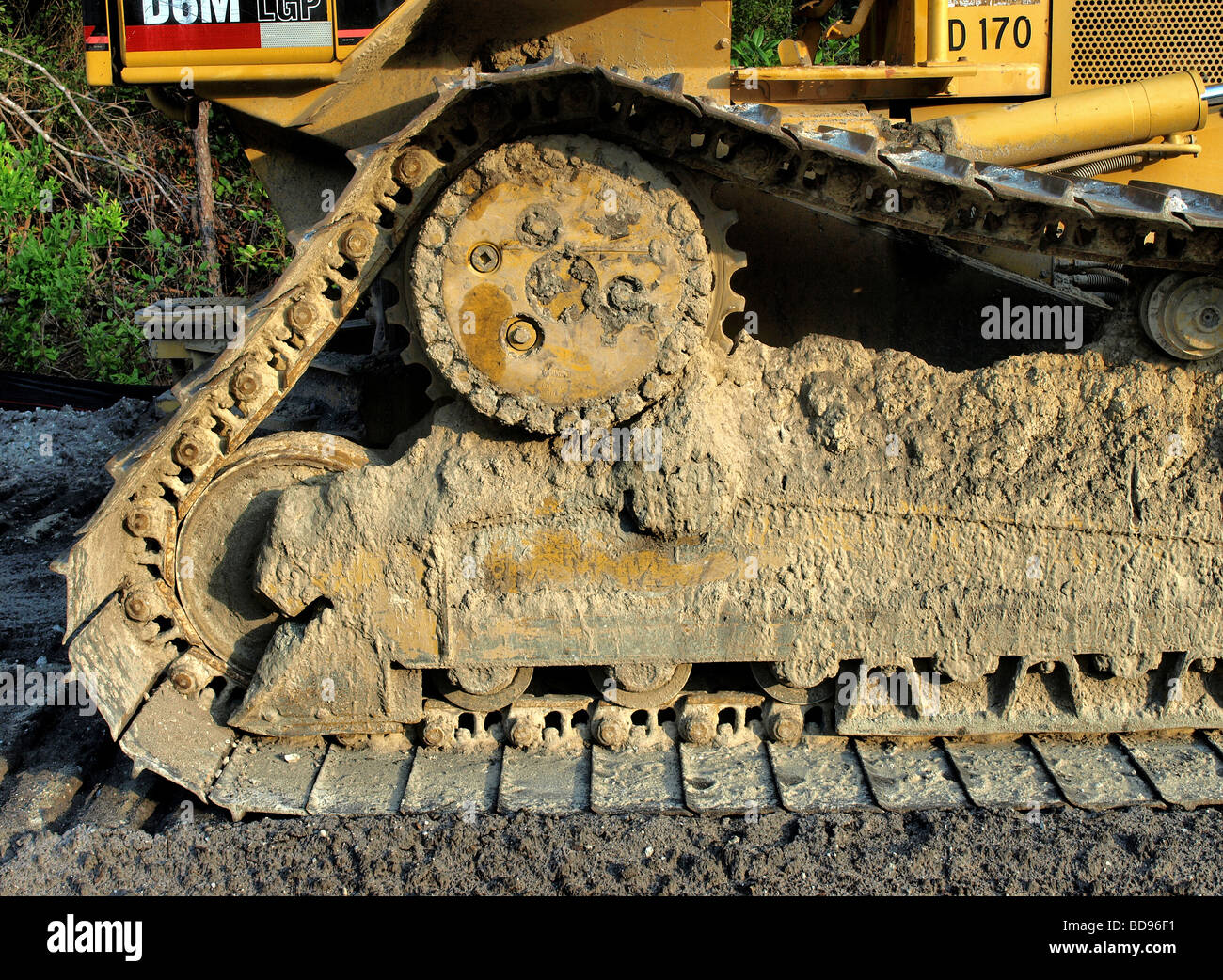construction equipment wheels on tread with dirt and yellow frame above