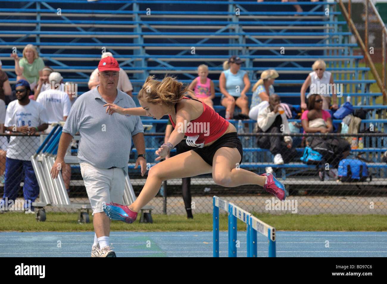 Female runner jumping over a hurdle at the Track and Field event during