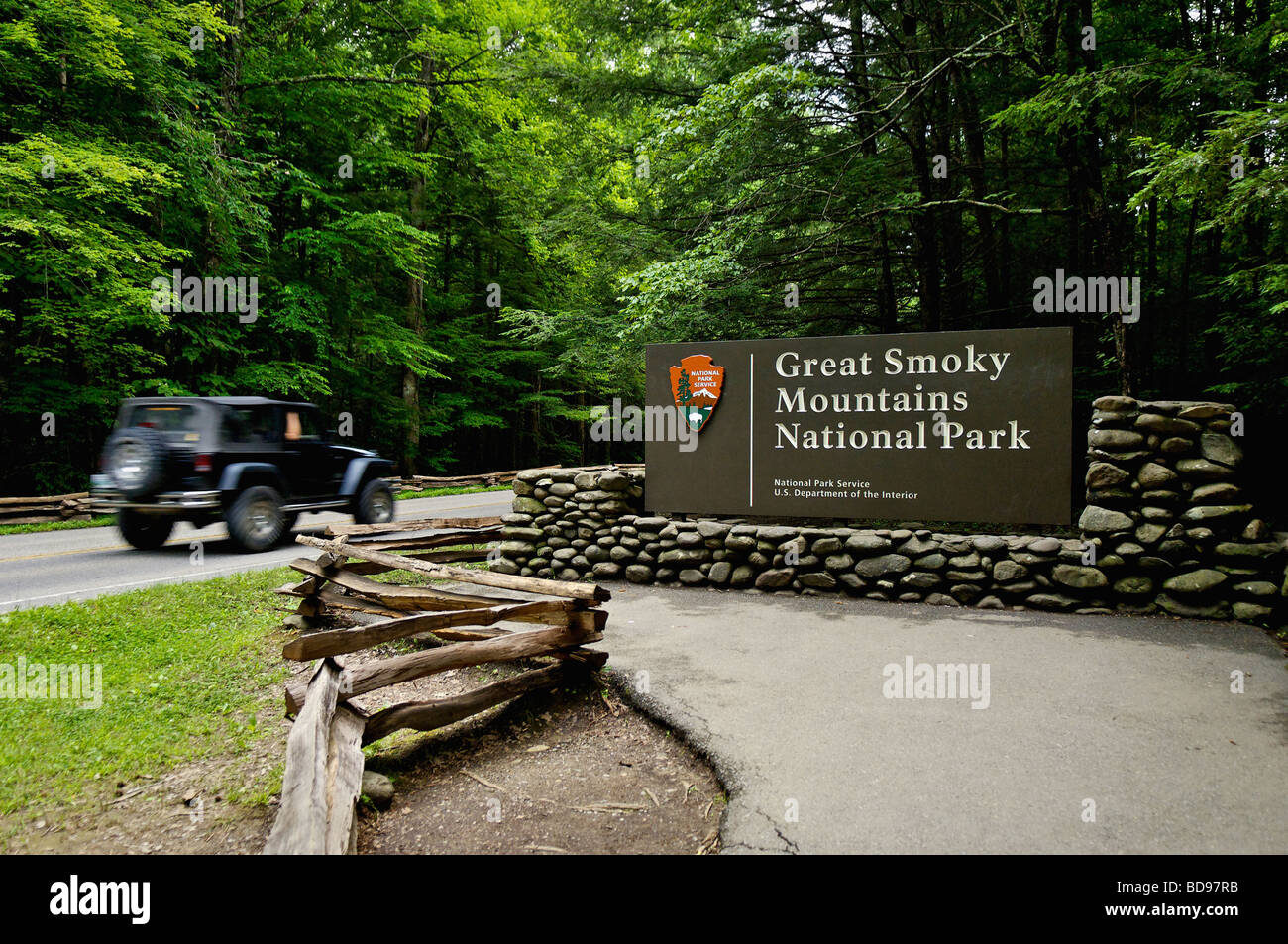 Jeep with Motion Blur Driving Past the Entrance Sign to the Great Smoky Mountains National Park on Route 441 in Tennessee Stock Photo