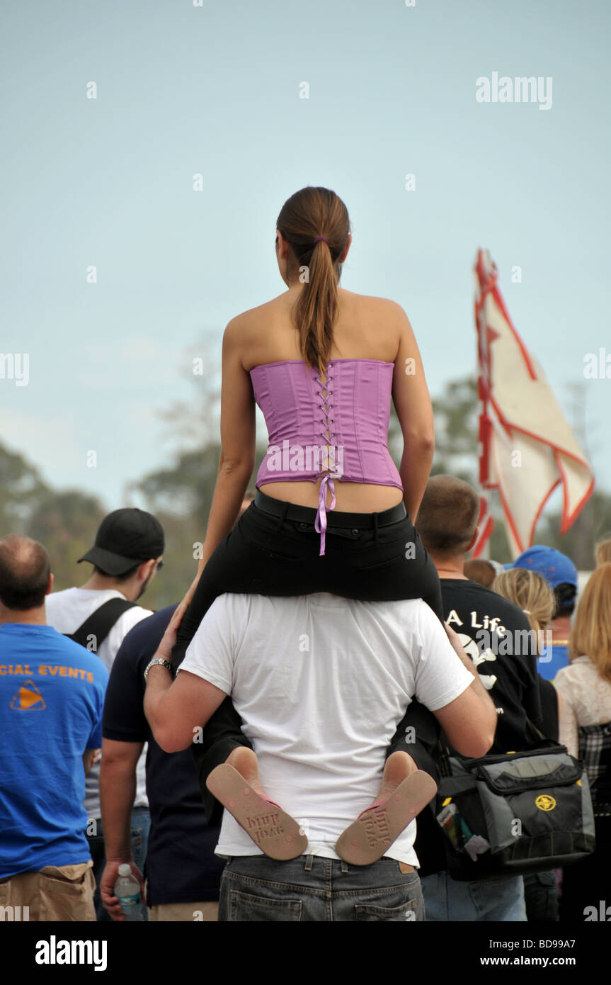 Girl sitting on boyfriend's shoulder for better view at a Renaissance