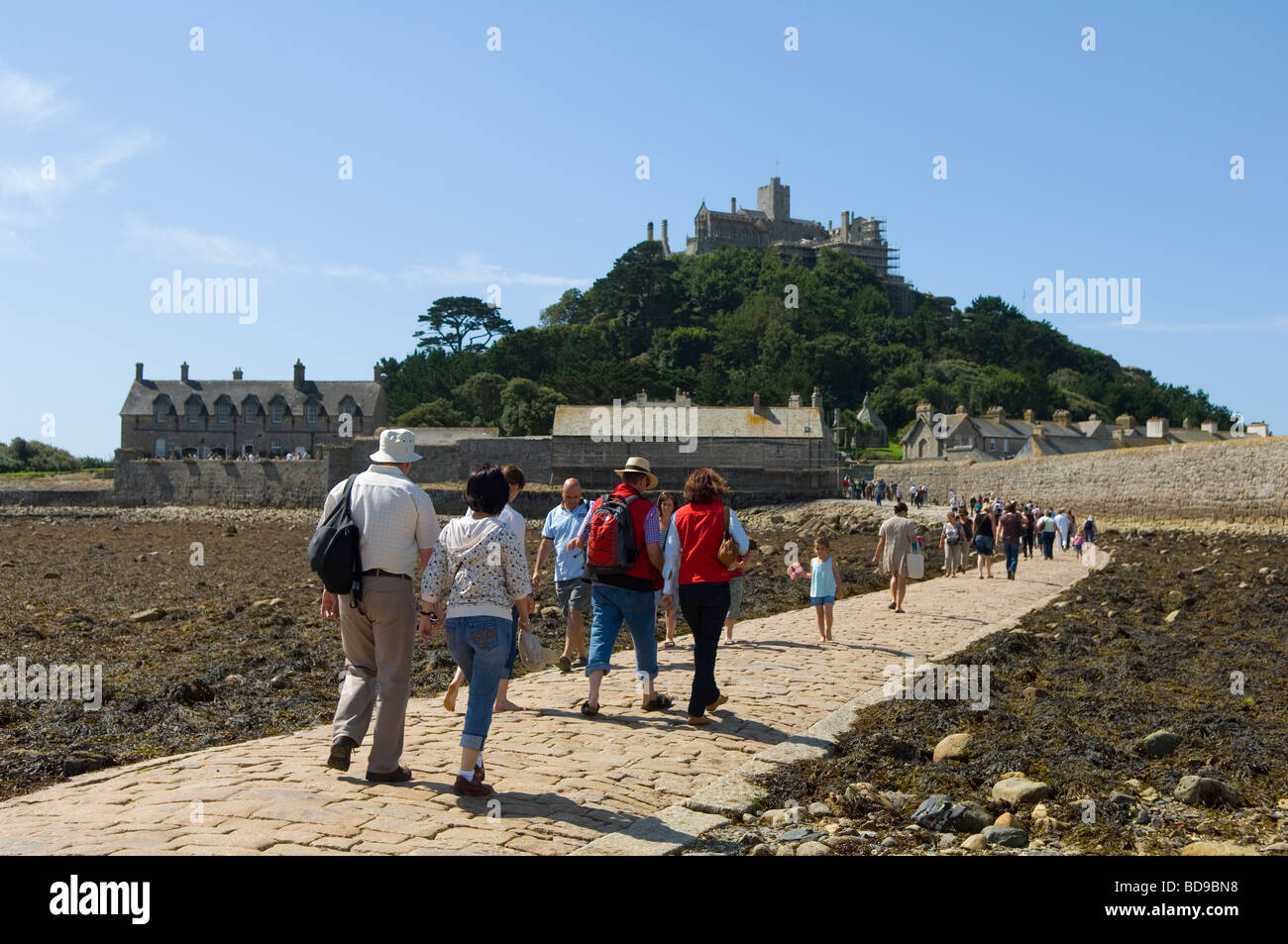 Tourists crossing the causeway at low tide to St Michael's Mount from Marazion on the Cornish mainland. Stock Photo