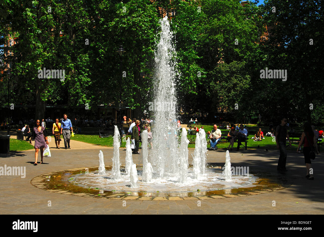 Park scene with fountain in Russell Square Gardens in Bloomsbury on a warm summer day, London, United Kingdom Stock Photo