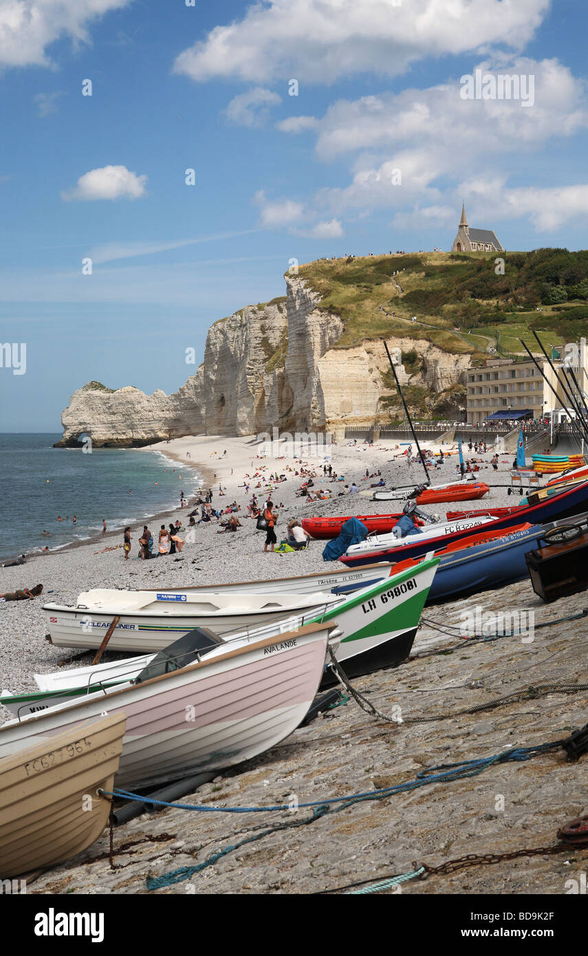 Fishing boats on the beach at Etretat with the chapel of Notre Dame and ...
