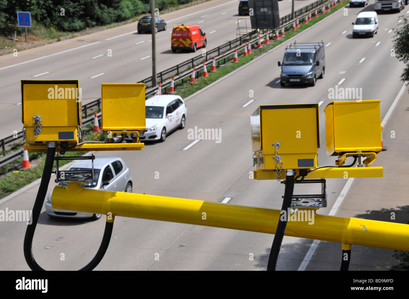 Aerial view of traffic on M25 motorway road widening construction project starting cluster four yellow overhead average speed cameras Essex England UK Stock Photo