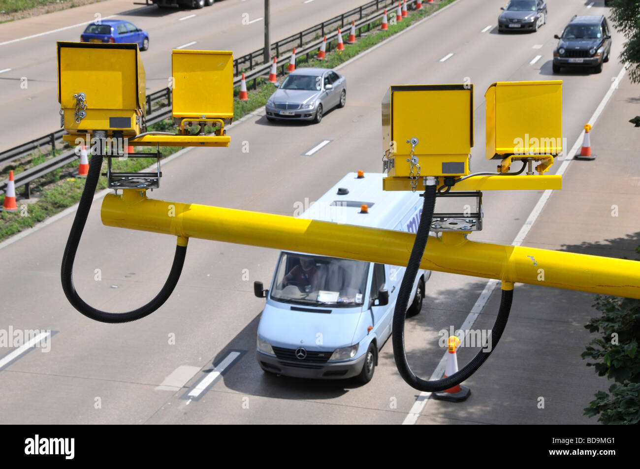 Aerial view motorists driving along M25 motorway road variable average speed cameras monitoring traffic entering a roadworks section Essex England UK Stock Photo