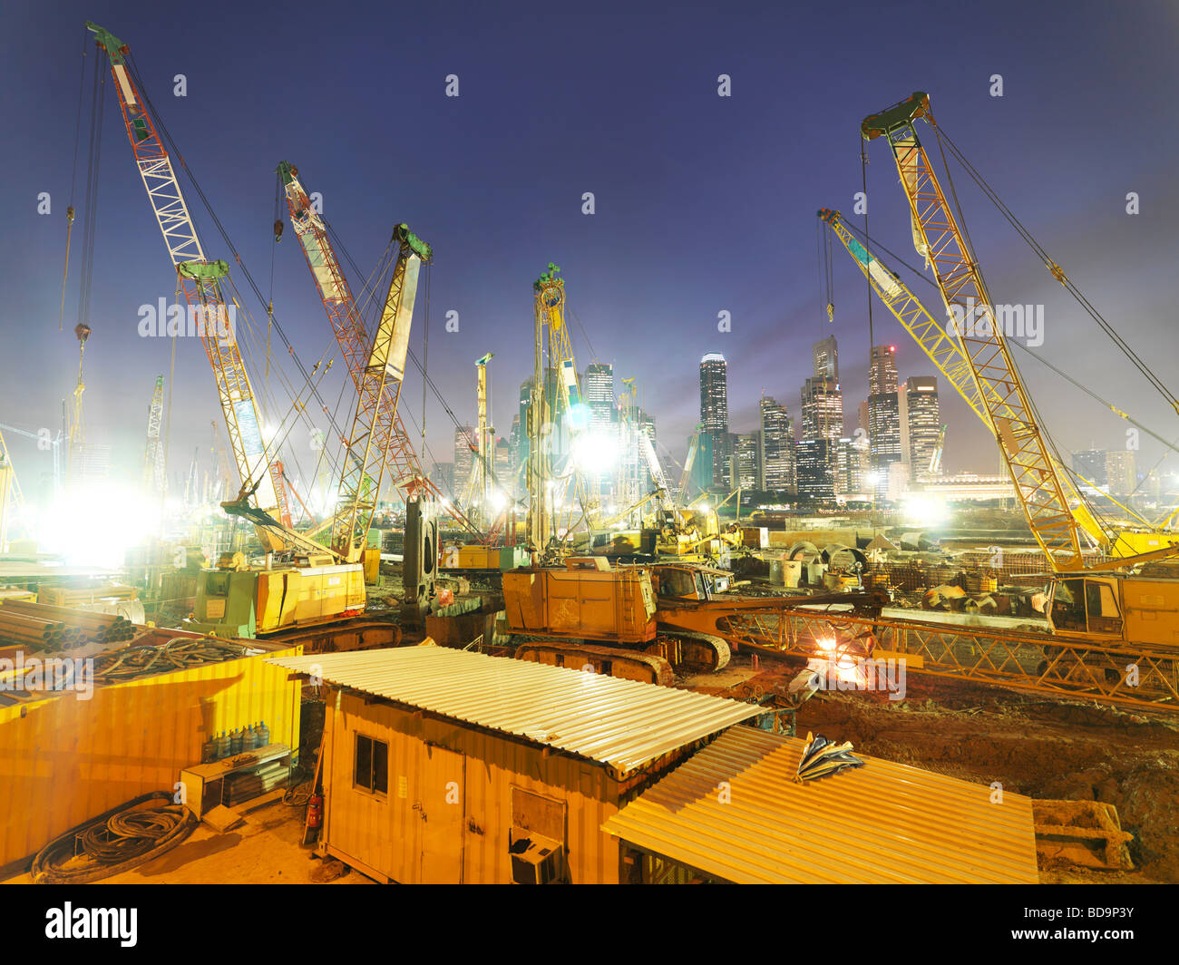 A forest of construction cranes working at a site along Singapore s East Coast Parkway highway. Stock Photo