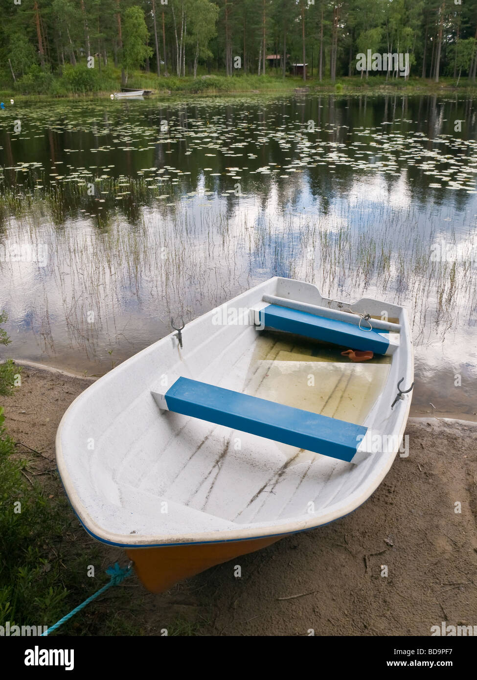 A small open boat on the shore of a small lake Stock Photo