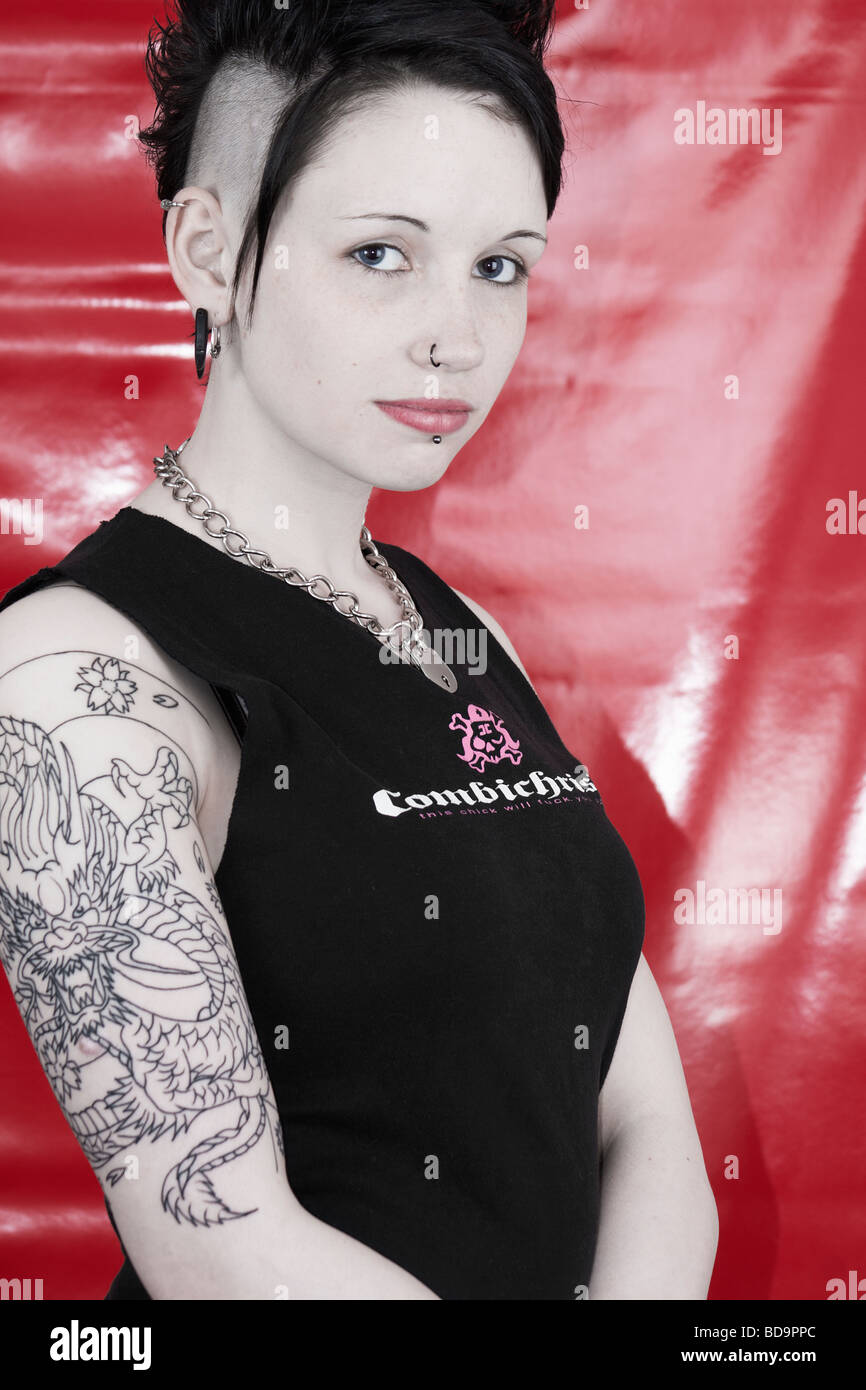 Attractive alternative female model with mohican hair cut, black clothing and piercings. Stock Photo