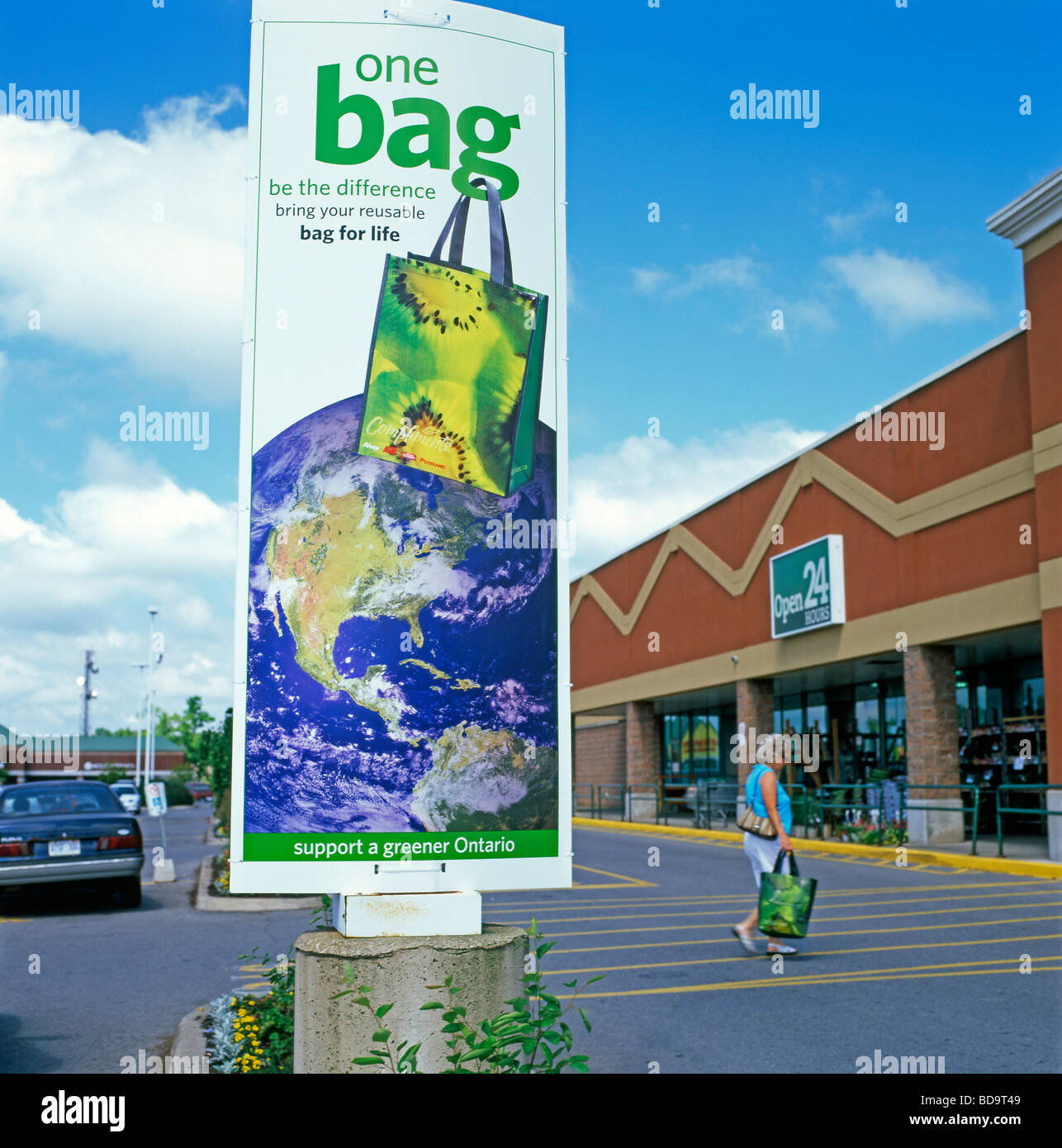 Sobeys supermarket reusable plastic shopping bag green advert with map of North America and shopper at entrance of store Ontario Canada  KATHY DEWITT Stock Photo