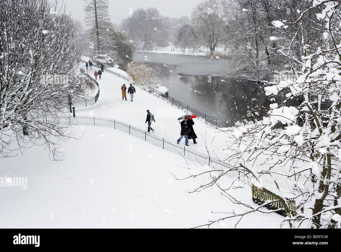 People walking through snow St James Park London England Stock Photo