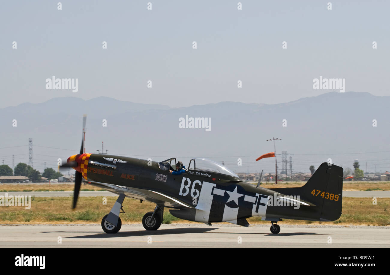 A P-51 Mustang taxis on the runway after flying at an air show. Stock Photo