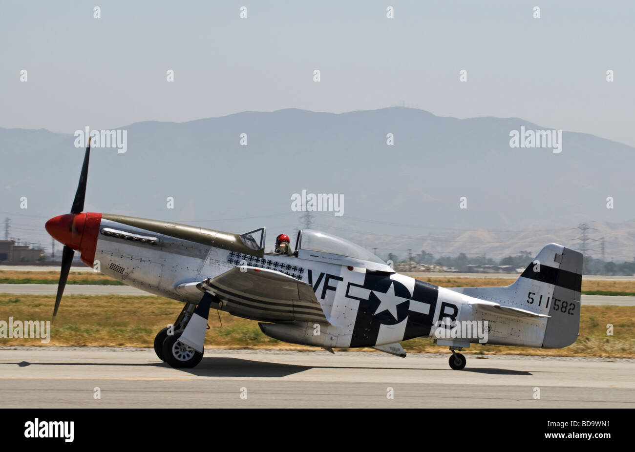 A P-51 Mustang taxis on the runway after flying at an air show. Stock Photo