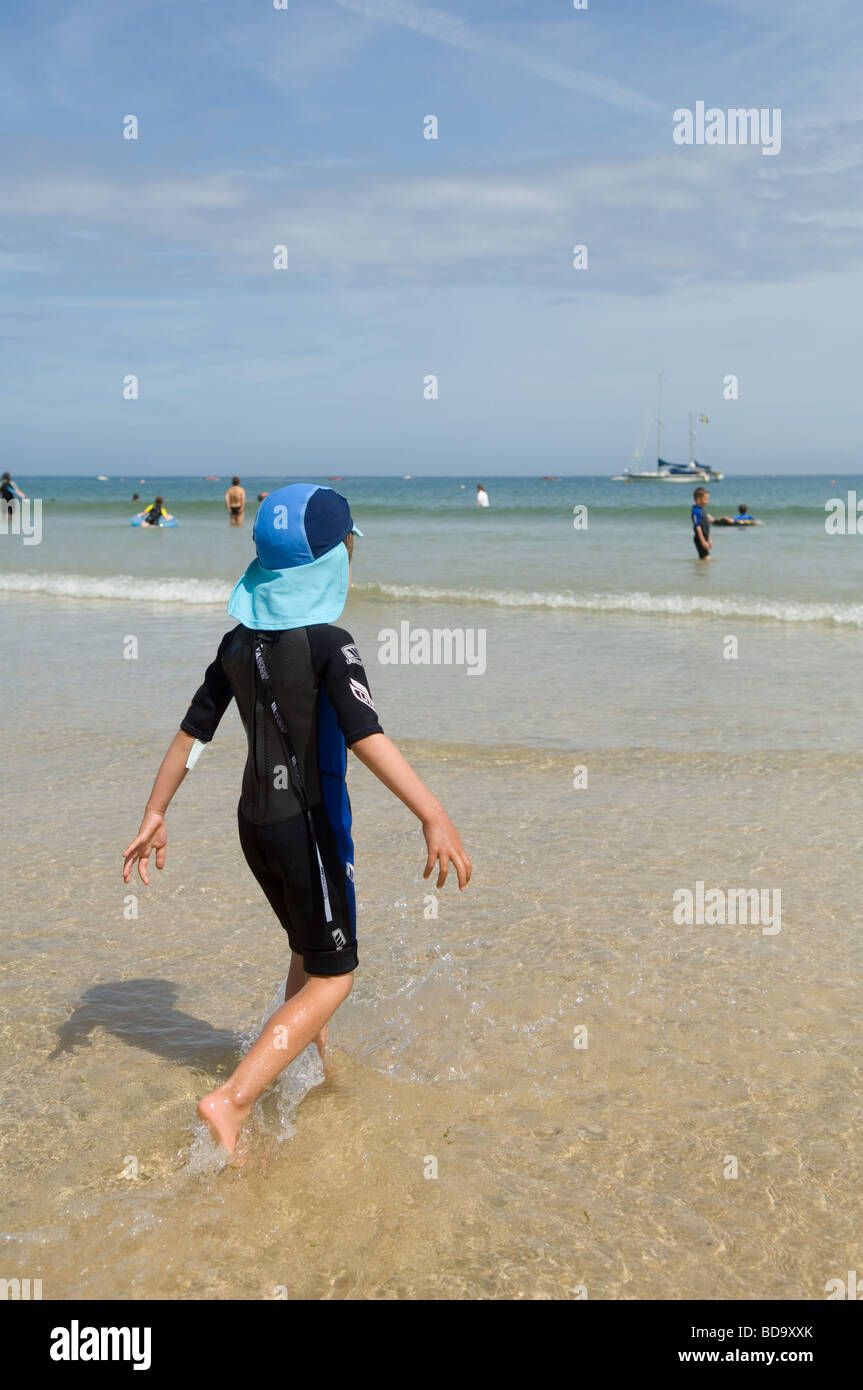 A six year old boy in a wetsuit on Porthminster Beach near St Ives