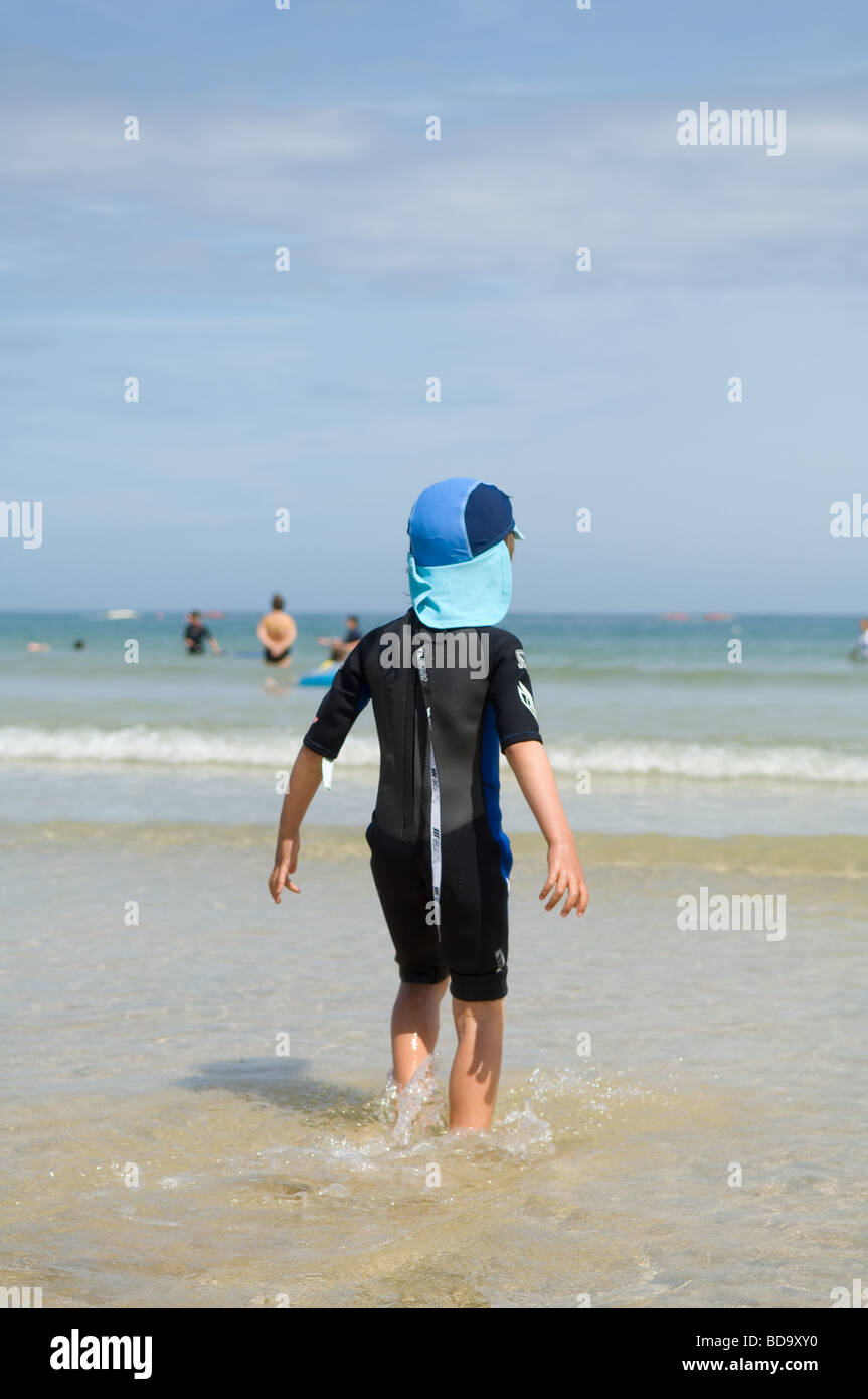 A six year old boy in a wetsuit on Porthminster Beach near St Ives