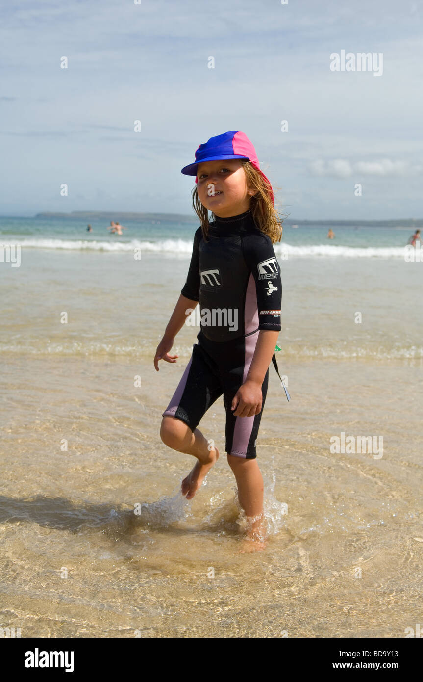 A five year old girl in a wetsuit on Porthminster beach near St Ives
