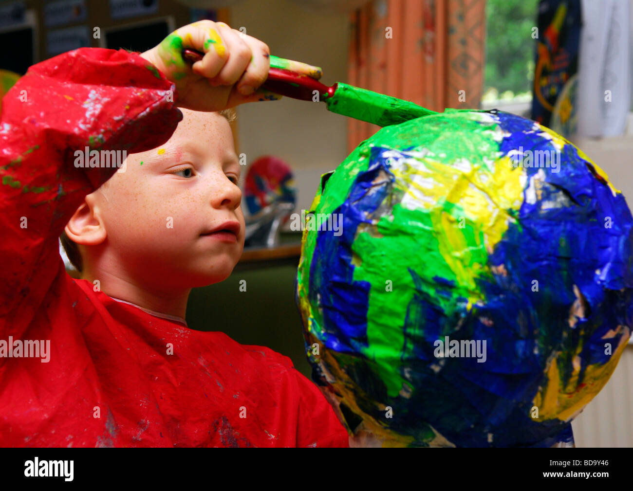 6 year old boy painting earth at Starship Holiday Club; an