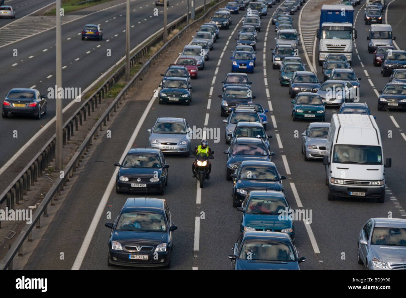 Motorcycle rides between slow moving traffic out of London at a