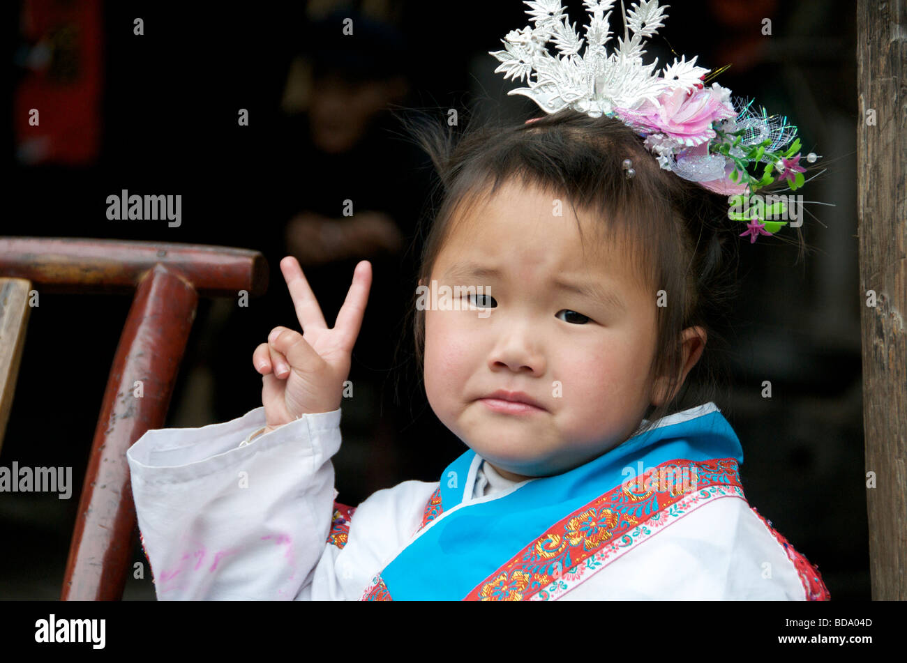 Small girl giving V sign Drum Festival Shidong Guizhou Province China Stock Photo