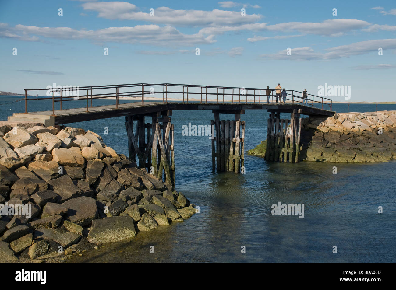A family walks across a bridge to a jetty in Plymouth Ma Stock Photo ...
