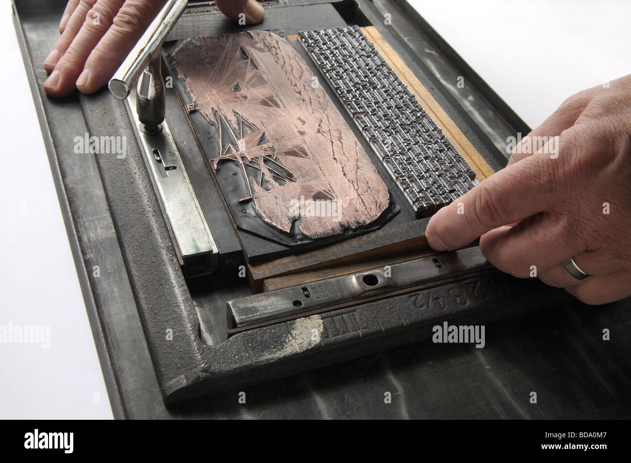 hands preparing printer's cut and letterpress metal type for printing Stock Photo