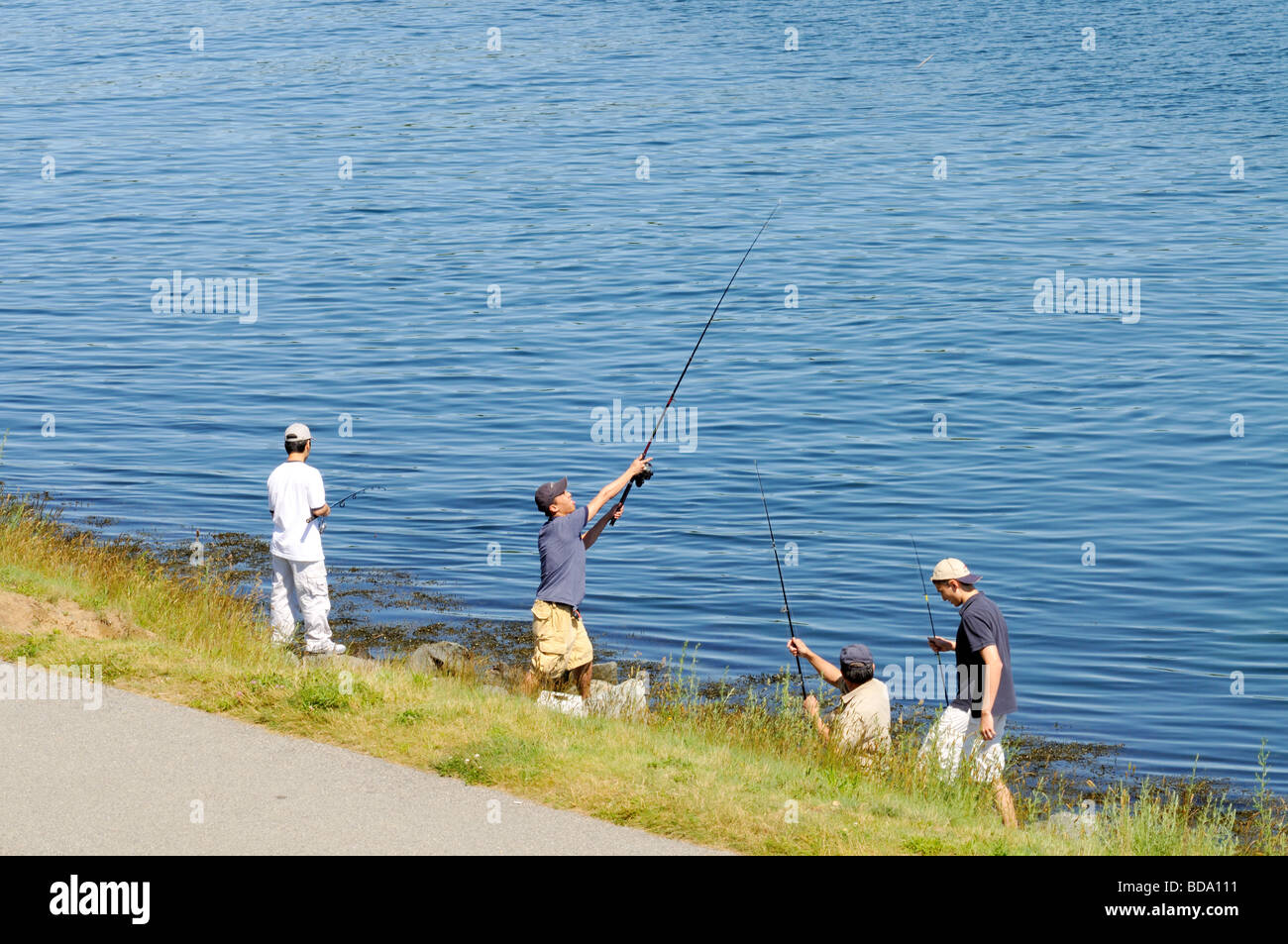 Kids fishing from banks of Cape Cod Canal Stock Photo