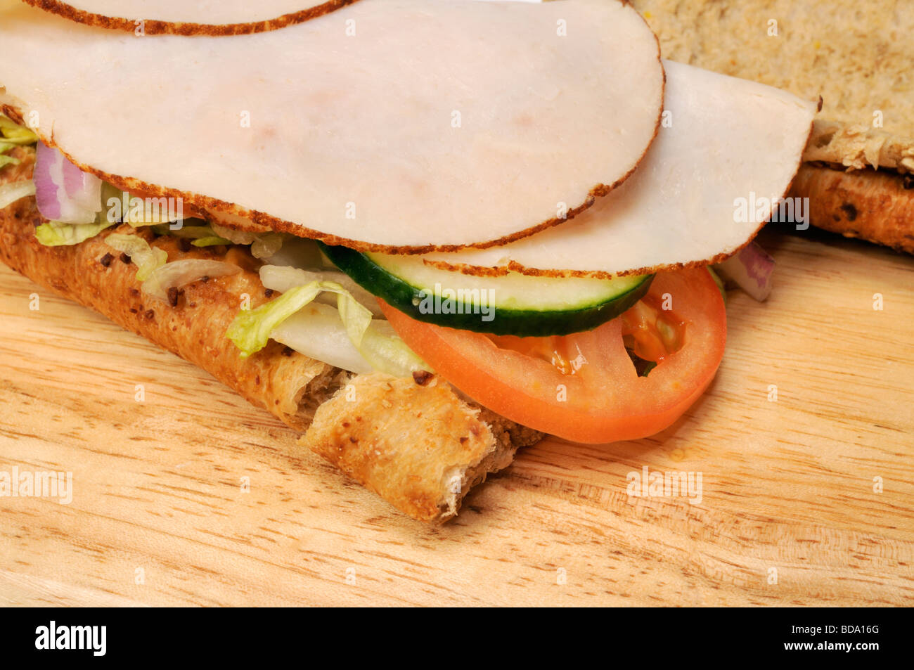 Close up of turkey sandwich with tomato, cucumber and lettuce . Stock Photo