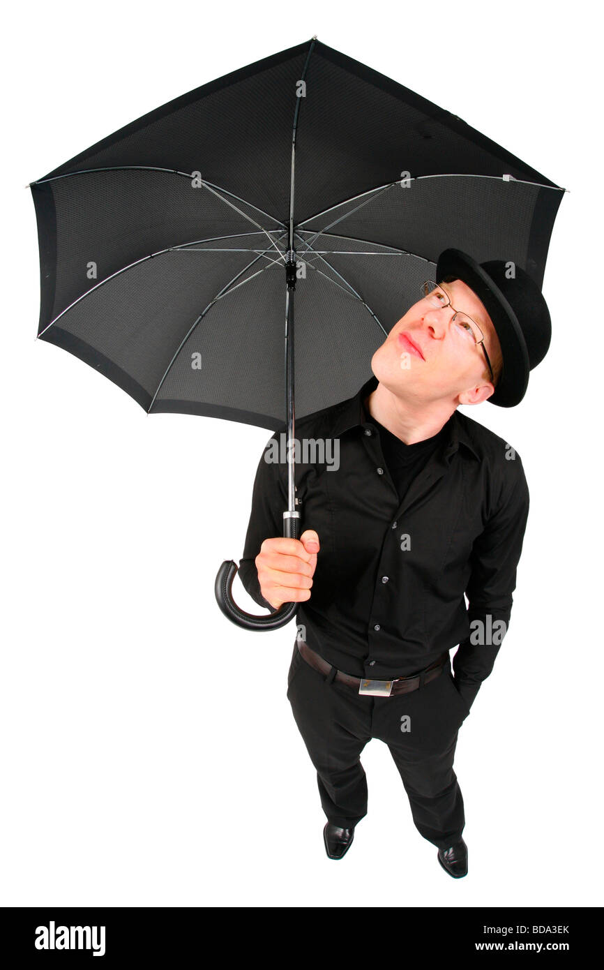 young man with bowler hat and umbrella waiting for rain Stock Photo