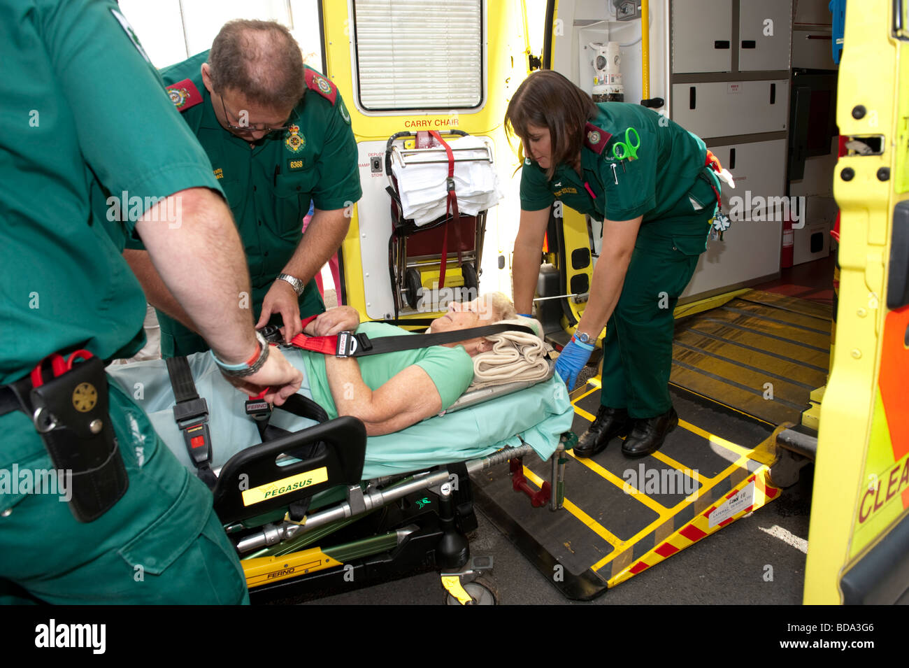 Paramedics responding to a 999 call putting elderly lady who has fallen over at home on a stretcher and taking her to hospital Stock Photo