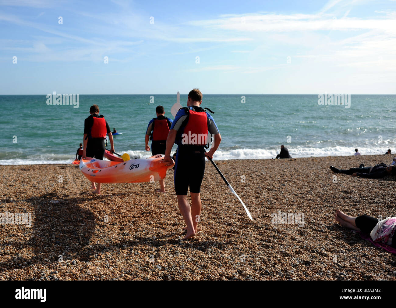 Kayak and canoe club struggle to launch on Brighton beach with waves knocking them over Stock Photo