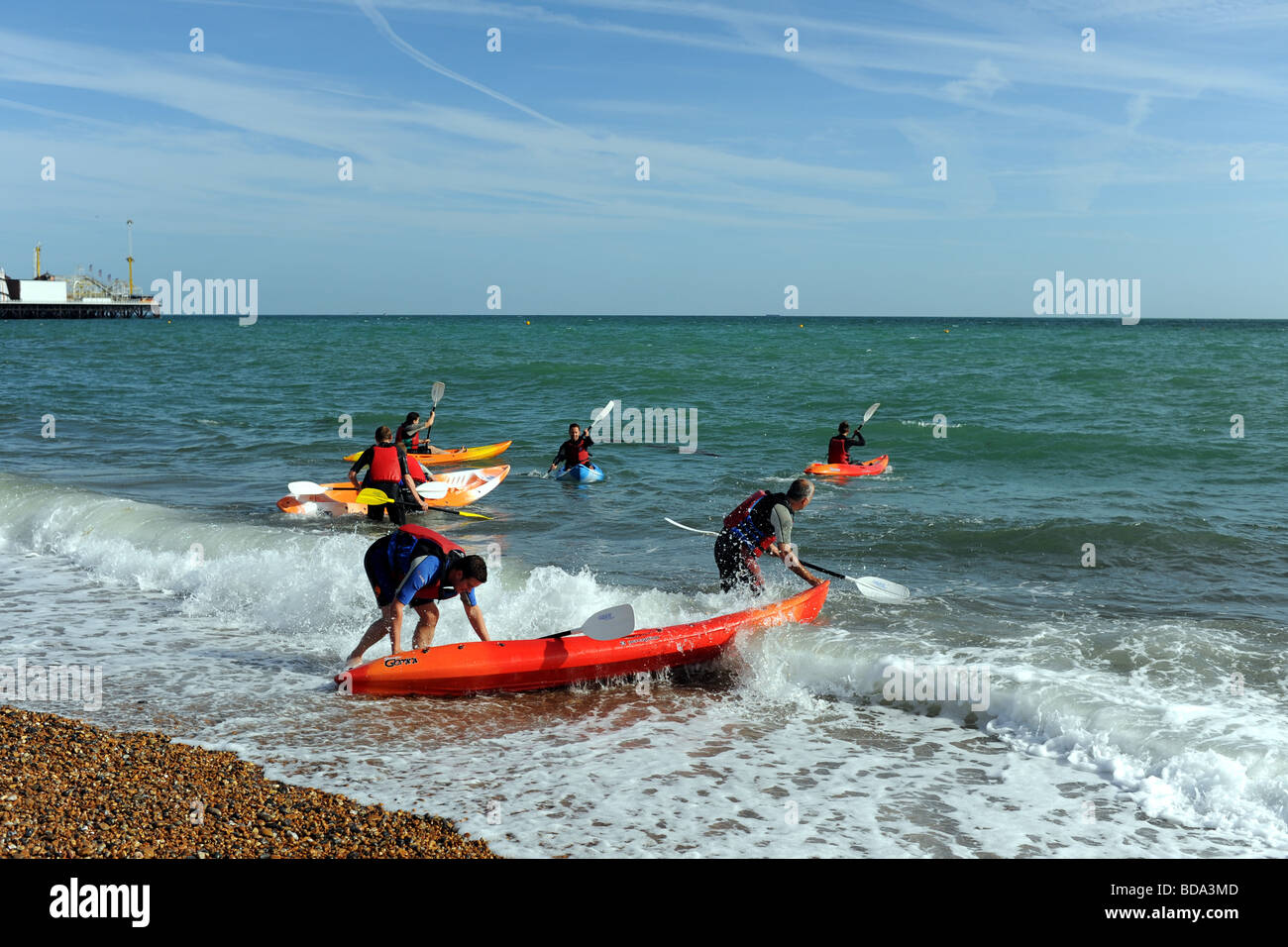 Kayak and canoe club struggle to launch on Brighton beach with waves knocking them over UK Stock Photo
