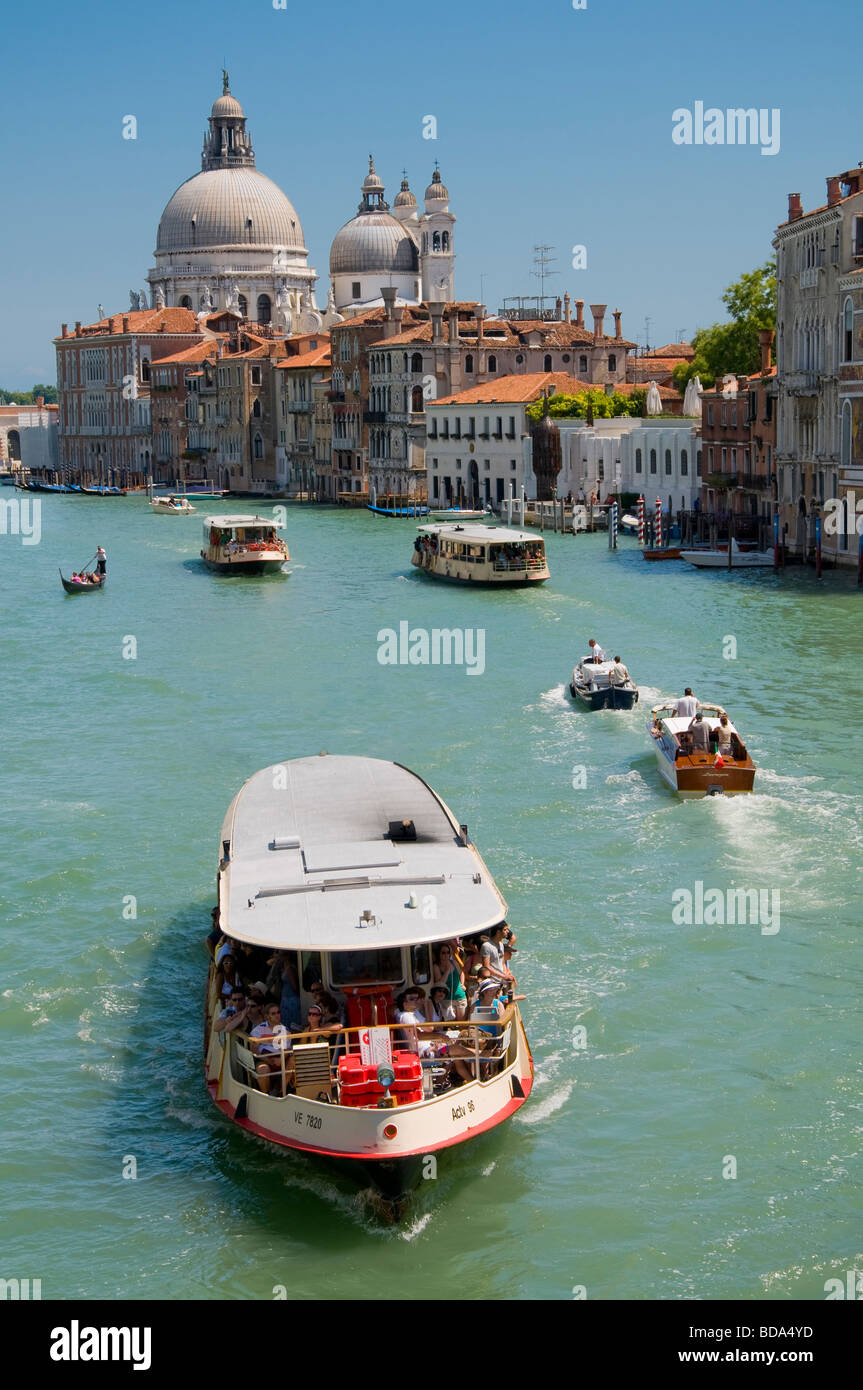 Venice, Veneto, Italy. Church of Santa Maria della Salute and Grand Canal from the Ponte dell'Accademia. Vaporetto / water bus Stock Photo