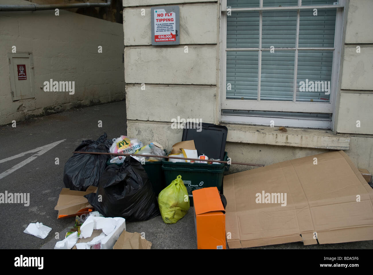 Rubbish dumped beneath a no fly tipping notice in the London Road, Bath Spa, Somerset UK Stock Photo