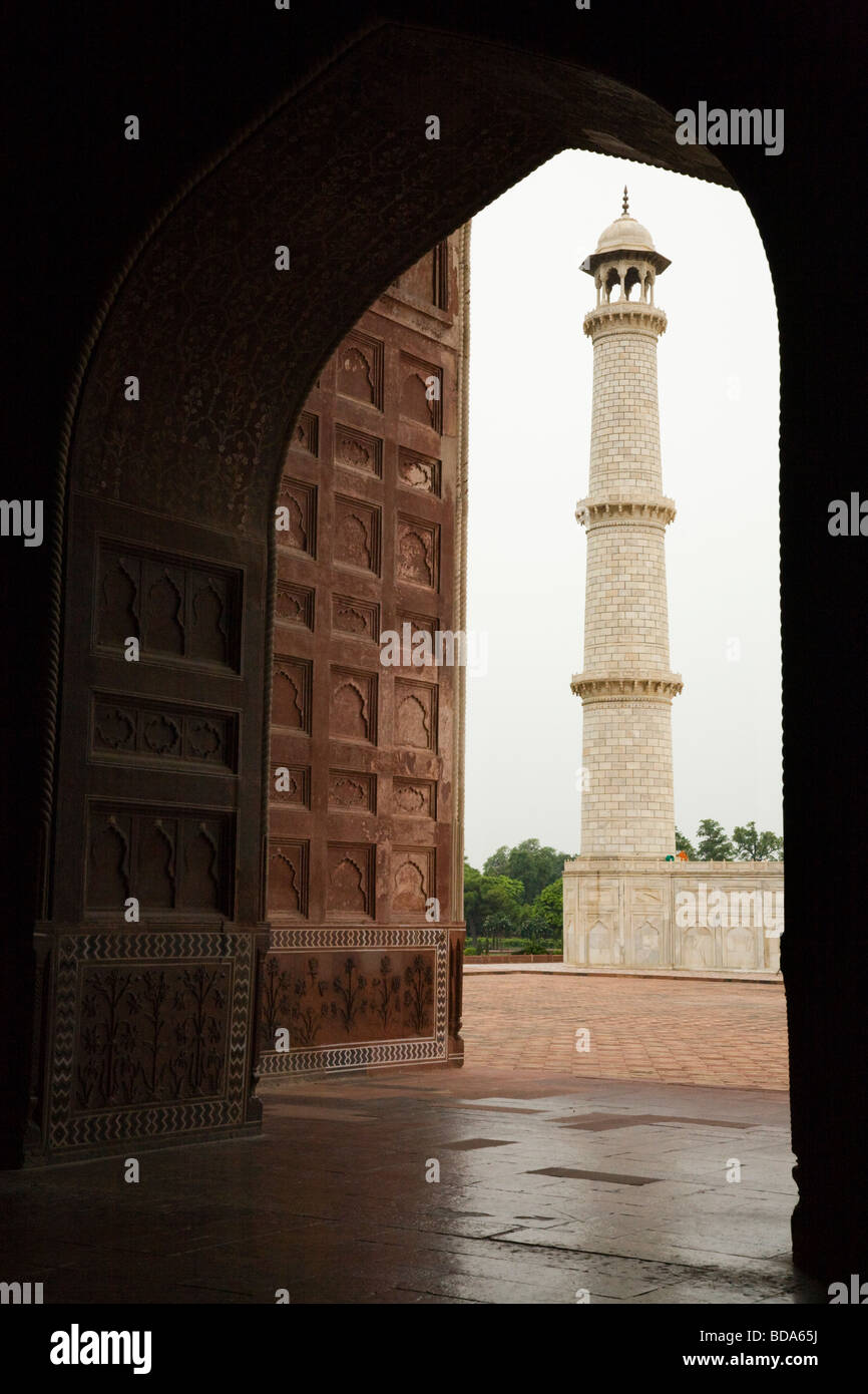 Minaret at the Taj Mahal mausoleum seen through an arched passageway within the Jawab, in the Taj Mahal complex. Agra. India. Stock Photo