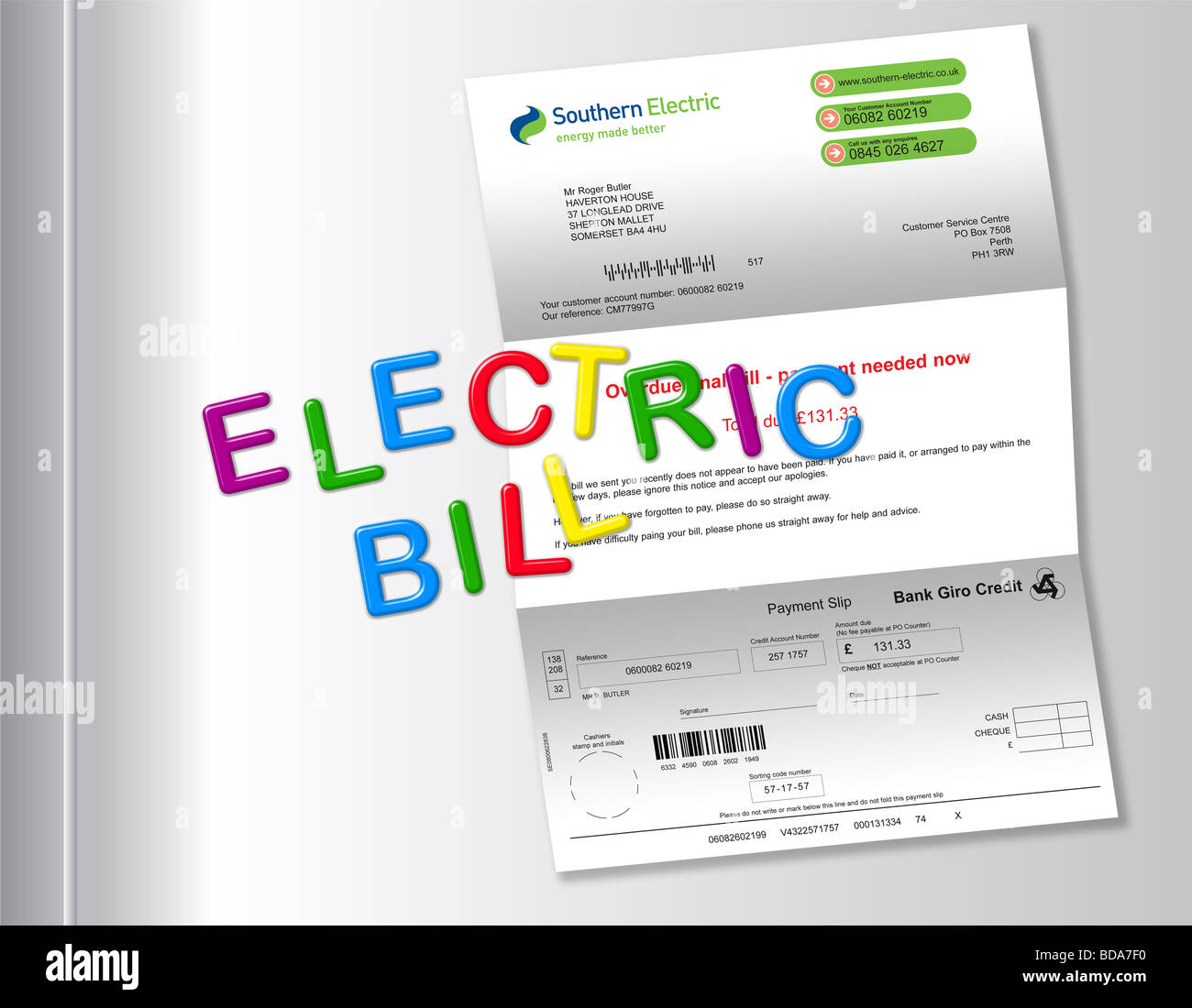 Electric bill on fridge with ‘ELECTRIC BILL’ spelt out by magnetic fridge letters. Stock Photo