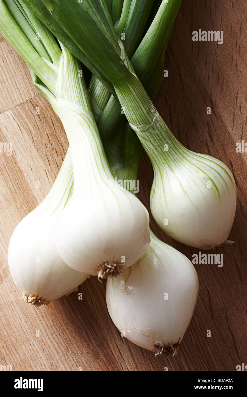 Spring Onions on wooden chopping board Stock Photo