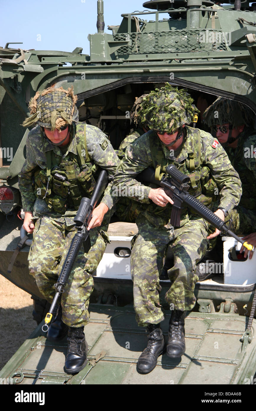 Canadian Soldiers with weapons at the ready pile out of a LAVIII armoured vehicle- Abbotsford Air Show 2006 Stock Photo
