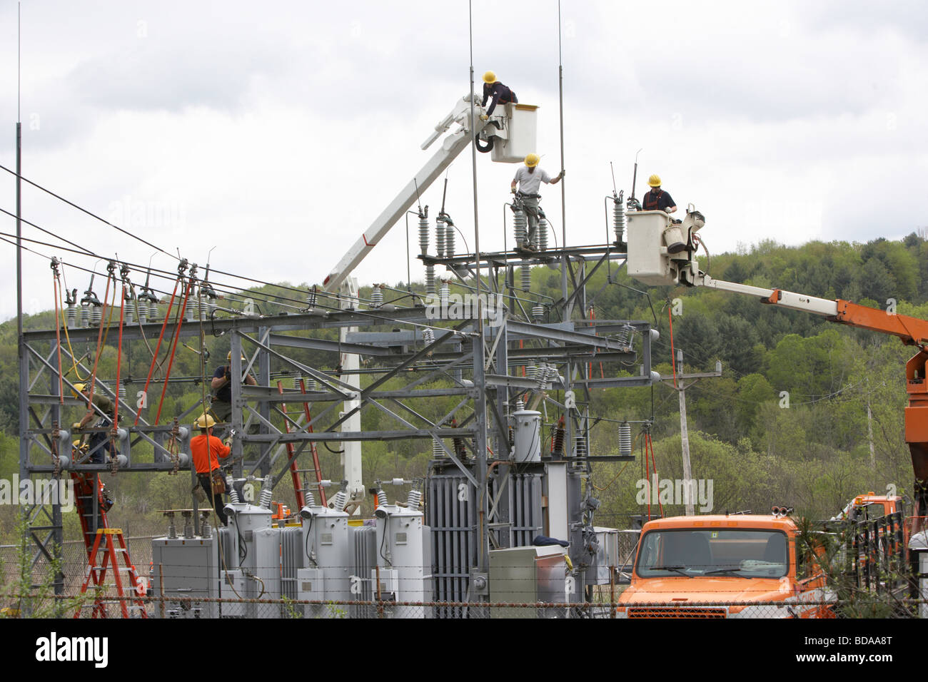 Utility workmen installing updated components to a city gate electrical