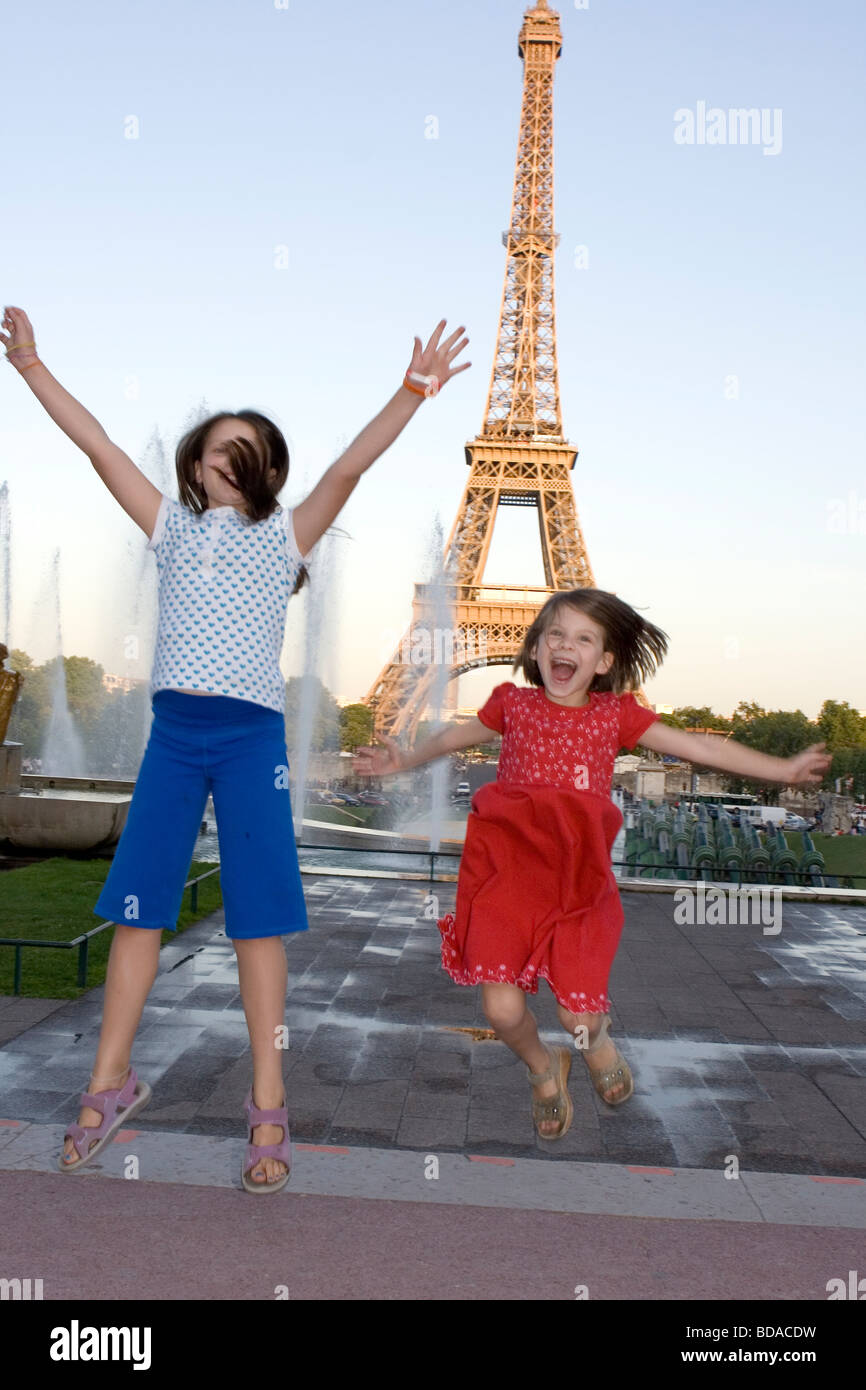happy children jumping around Eiffel Tower in Paris Stock Photo