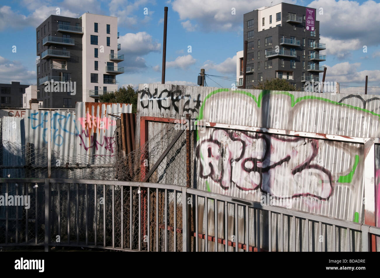 Graffiti on corrugated iron fence and flats, Hackney Wick Stock Photo