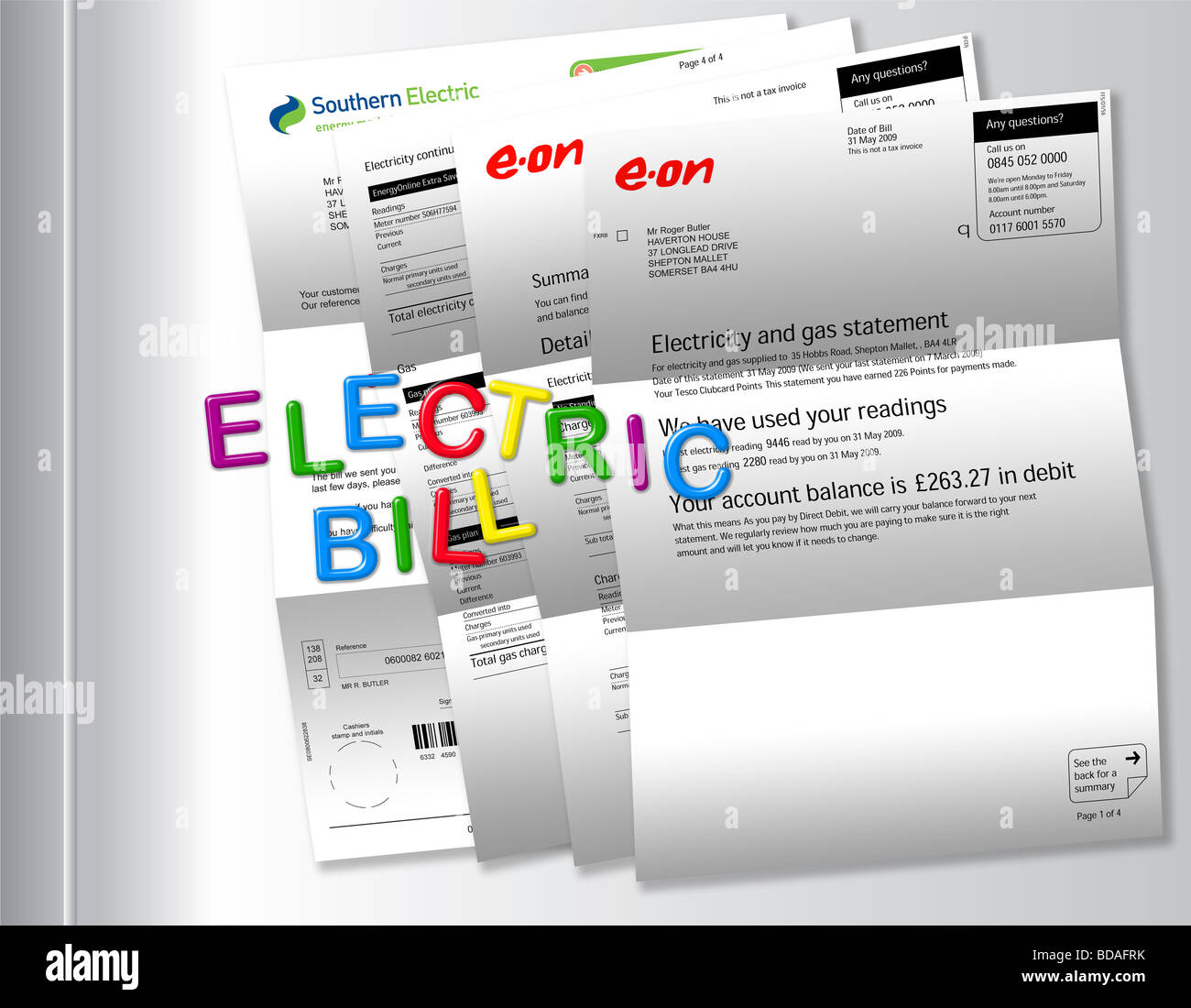 Electric bills on fridge with ‘TO BE PAID’ spelt out by magnetic fridge letters. Stock Photo