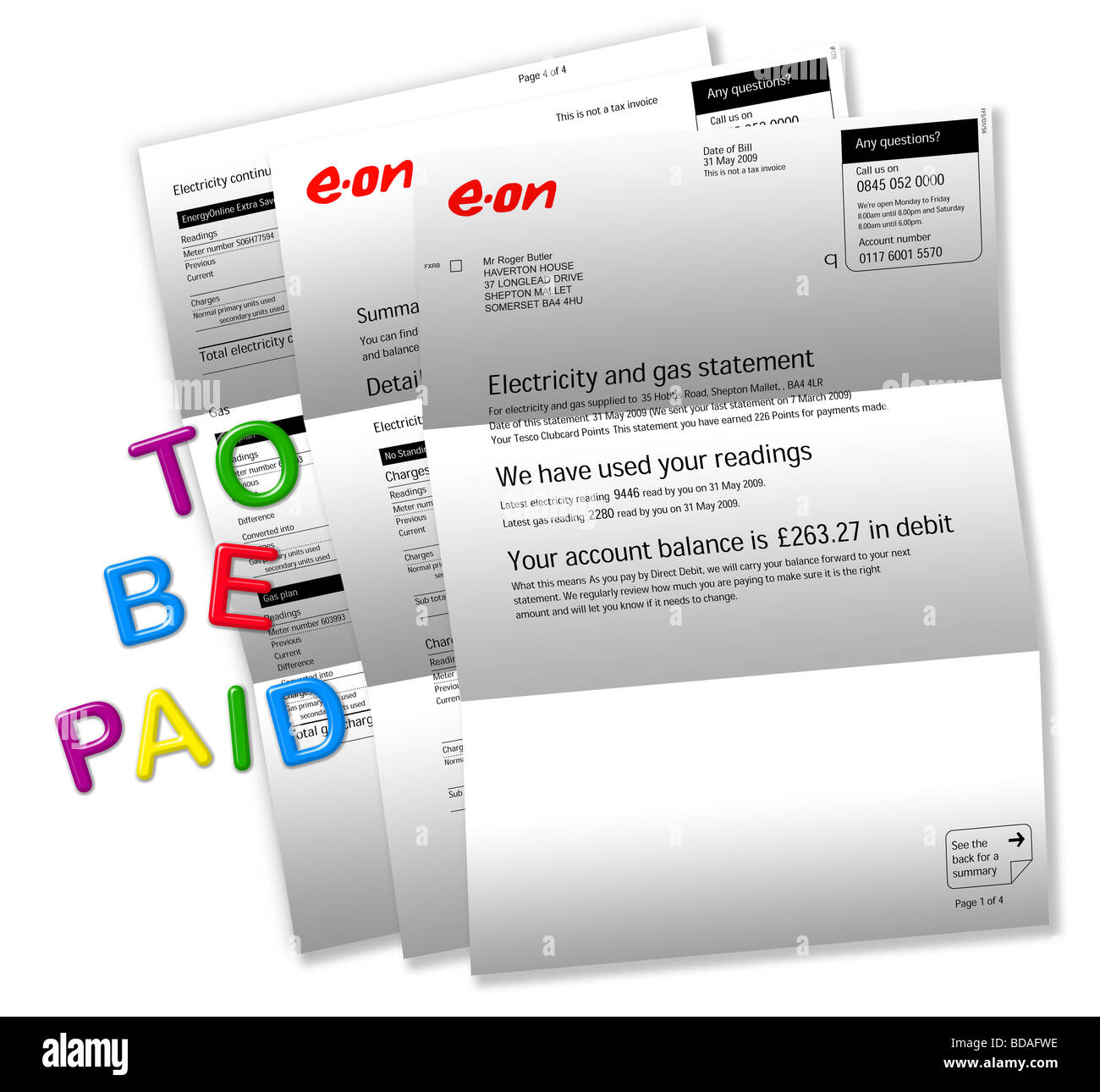 Electric bills on white with ‘TO BE PAID’ spelt out by magnetic fridge letters. Stock Photo