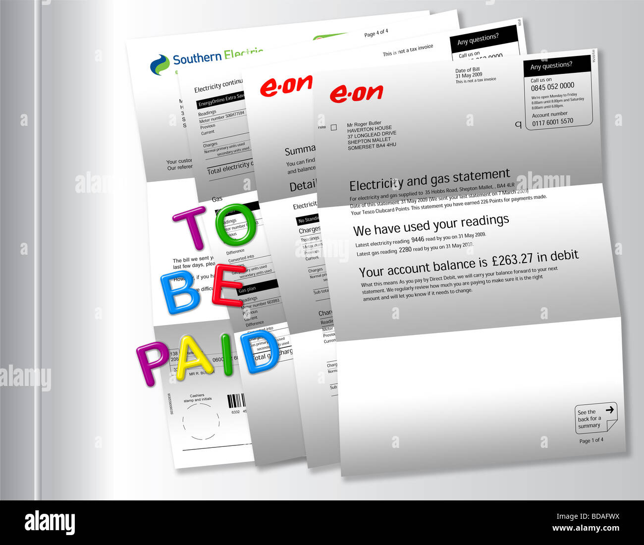 Electric bills on fridge with ‘TO BE PAID’ spelt out by fridge