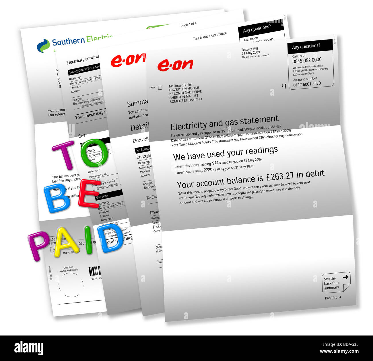 Electric bills on white with ‘TO BE PAID’ spelt out by magnetic fridge letters. Stock Photo