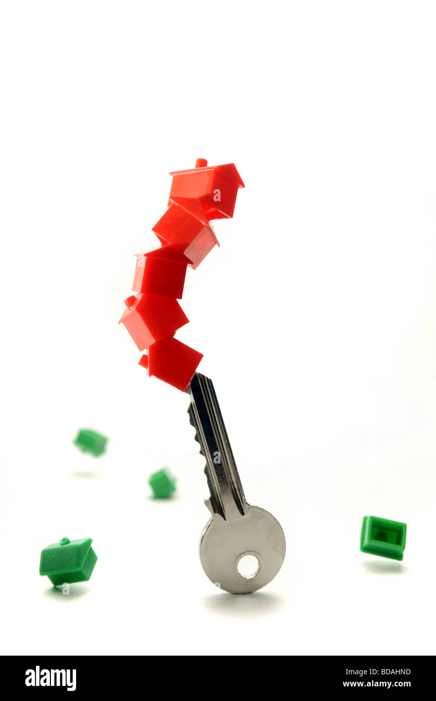 MODEL HOUSES BALANCING AND FALLING FROM A HOUSE KEY RE HOUSING MARKET/ INTEREST RATES/RATE/BUYING/SELLING/HOMES. Stock Photo