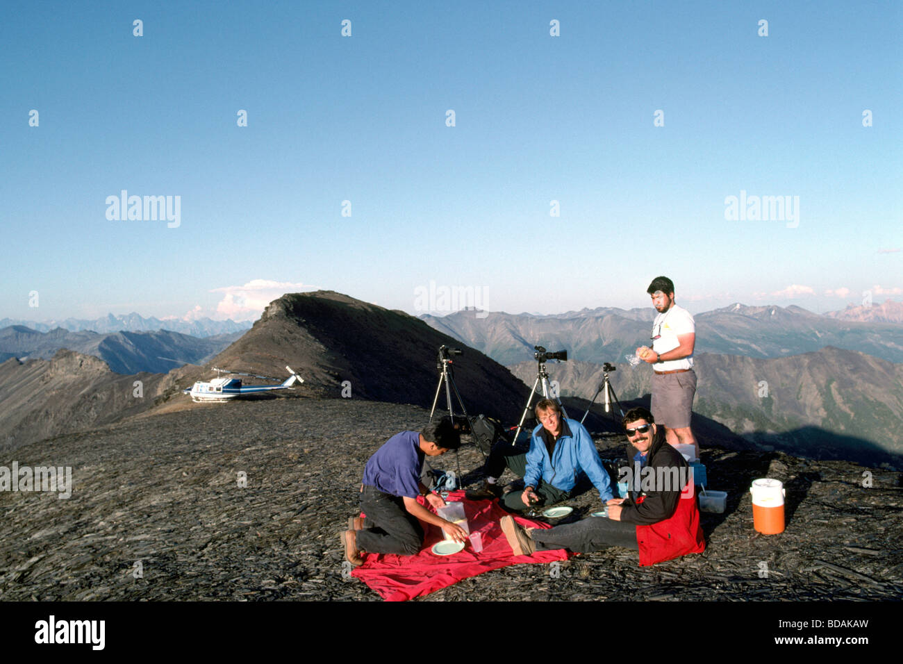 Photographers eating Alpine Picnic Lunch on Helicopter Trip to Purcell Mountains Bugaboo Provincial Park British Columbia Canada Stock Photo